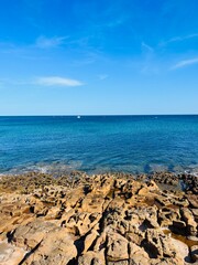 Wall Mural - Beautiful azure ocean horizon, rocky coast, clear blue sky