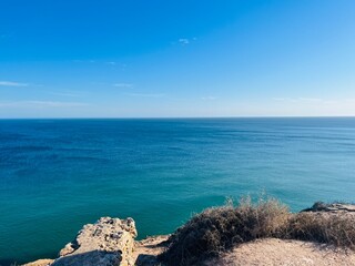 Wall Mural - Blue ocean horizon, rocky coast, ocean bay