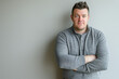 © Alienmonster Images - Confident Businessman in Casual Wear Standing Against Neutral Background with Arms Crossed