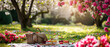Picnic at blooming spring garden. Cute Wicker basket with flowers, meal. Tablecloth on the grass in a park. Outdoors rest. Breakfast on the nature. Generative ai