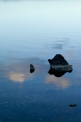 Wall Mural - reflections in water and black rocks at the lagoon of Casaraccio. Stintino. Sassari, Sardegna. Italia.