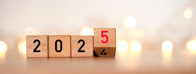 Wall Mural - flipping of 2024 to 2025 on wooden block cube with yellow light bokeh for preparation new year chang