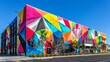 Vibrant, abstract mural adorning the facade of a contemporary architecture building against a clear blue sky.