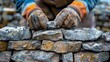 A bricklayer constructs a stone wall using wood, metal tools, and building materials like bricks and rocks 