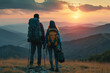 Close up back view of a calm young woman and man with a travel backpack standing on rock looking at mountains. Travelling concept.
