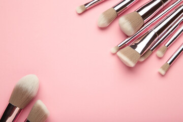 Wall Mural - Set of makeup brushes on pink background. Top view. Space for text