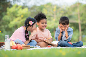 happy family enjoying a picnic in the park, children are having fun drawing on paper.