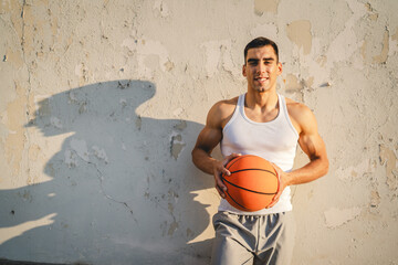 Poster - Portrait of strong athlete man hold basketball ball wear white a-shirt