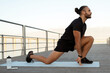 © Prostock-studio - man flexing legs in kneeling hip flexor stretch exercising outdoors