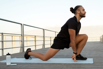 man flexing legs in kneeling hip flexor stretch exercising outdoors