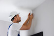 © ronstik - security system technician installing motion sensor on the wall at home