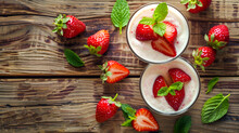 Tasty cream and strawberries in the bowl on the table. Fresh and tasty strawberries under yogurt in glass bowl,Strawberry tiramisu trifle custard dessert in a glass with fresh strawberry,
