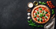 Une délicieuse pizza tomate mozzarella basilic avec des couverts et une serviette vue de dessus sur un fond en ardoise