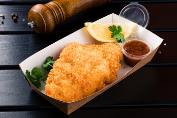 Wall Mural - Lunch box fried breaded chicken fillet with lemon, parsley and sauce.