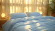 a bed with a blue comforter and pillows in front of a window with sunlight streaming through the drapes.