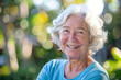 © Hunman - Lovely Seventy Year Old Woman Smiling in Blue Shirt with Copyspace.