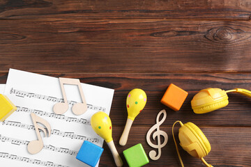 Sticker - Baby song concept. Wooden notes, music sheet, headphones and toys on table, flat lay. Space for text