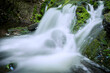 Flowing water in waterfall between rocky stream in the mountains