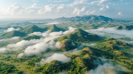 Wall Mural -  an aerial view of a mountain range with clouds in the foreground and a blue sky with a few white clouds in the middle of the top of the picture.