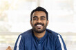 © fizkes - Cheerful attractive young Indian man head shot front portrait. Happy handsome guy in casual denim shirt looking at camera with perfect toothy smile, showing white teeth. Video call screen
