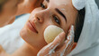 Cotton pad or sponge are used to clean the skin. Woman face getting facial care by beautician hands at spa salon