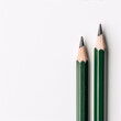 Two sharpened green pencils on a white background.