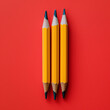 Three sharpened yellow pencils on red background, arranged vertically, minimalist still life photography
