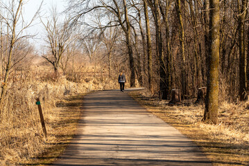 Sticker - A Woman Walking On The East River Trail In Early March In De Pere, Wisconsin