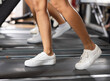 © JackF - Feet of woman in sneakers training on treadmill in gym close-up