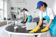 © Pixel-Shot - Female janitor cleaning table in office