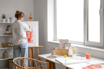 Wall Mural - Female artist with painting in workshop, back view