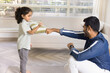 © fizkes - Positive strong Indian dad training little daughter kid, teaching boxing, showing fist work. Cute girl and young father exercising at home together, learning martial arts, fighting