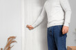 © Pixel-Shot - Young man closing door in living room