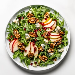 Wall Mural - Salad with autumnal elements: wild arugula, pomegranate seeds, pear slices, Ewe's blue cheese, walnuts, drizzled with balsamic dressing, served on a white round plate against a white background in a t