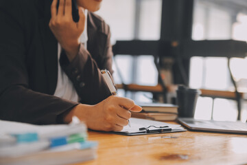 Asian Businesswoman working on laptop at the office with documents on his desk, doing planning analyzing the financial report, business plan investment, finance analysis concept