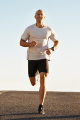 Canvas Print - Man, running in street and fitness for cardio, health and fresh air when training for marathon with sky background. Sports, exercise and athlete in portrait for workout, wellness and endurance