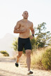 © Katie/peopleimages.com - Man, shirtless and running outdoor for fitness, cardio and health in park with fresh air and training for marathon. Sports, exercise and athlete in nature for workout, wellness and endurance for body