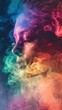 displays a profile view of a person's face partially obscured and surrounded by swirls of multicolored smoke. has a very artistic feel to it, with the smoke giving off a dynamic mi
