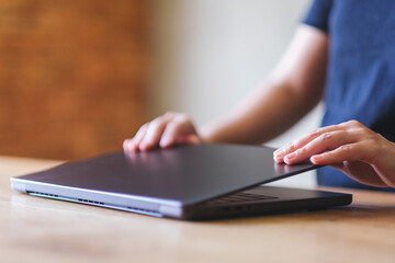 Wall Mural - a woman opening or closing laptop computer, getting ready for work