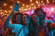 Group of happy friends taking selfie in front of stage on music festival at night