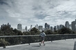 © Charnchai saeheng - A man running up on footbridge in the city center park for cardio workout.  Health and Lifestyle in big city life concept.