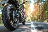 Fototapeta  - motorcycle on asphalt road in summer, A motorcycle is parked on a road with trees in the background