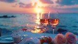 Fototapeta Natura - Romantic sunset dinner on the beach. Honeymoon table set for two with luxury dining Enjoy a glass of rose wine in a restaurant with a sea view. Happy Valentine's Day.