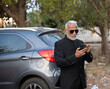 © Ojas - Lifestyle shot of senior Indian man wearing a suit working on a phone Digital India and digitally literate citizens