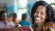A woman with curly hair is smiling and holding a book. The book is open to a page with a picture of a woman and a man. The woman is wearing a colorful outfit and she is enjoying her time reading