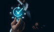 © PlengPleng - Quality control assurance QC, QA Concept. Businessman Holding Glowing Bulb with Check Symbol. Close-up of a businessman's hand holding a light bulb with glowing checkmark surrounded by business icons.