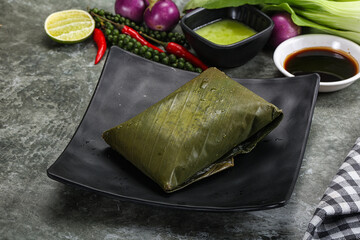 Wall Mural - Asian cuisine - rice with filling in banana leaf