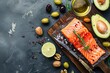 Food sources of healthy unsaturated fat and omega 3: fresh raw salmon fillet, avocado, olives, nuts on cutting board, rustic stone background top view. Healthy nutrition and keto diet, space for text 