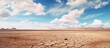 Harsh Desert Landscape with Cracked Earth Under a Gloomy Blue Sky