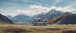 Vintage Van Parked in Serene Grassy Field with Majestic Mountain Range Background
